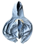 Flat lay of folded light blue Faceless sweatshirt showing centered face appliqué detail
