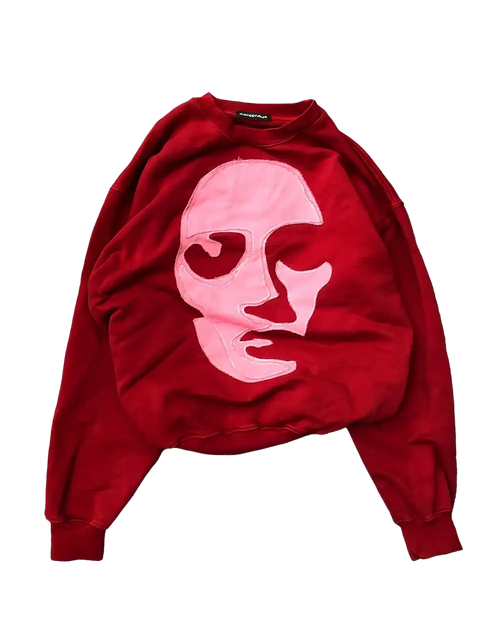 Red oversized crewneck sweatshirt with pink-toned frayed face appliqué and ribbed cuffs
