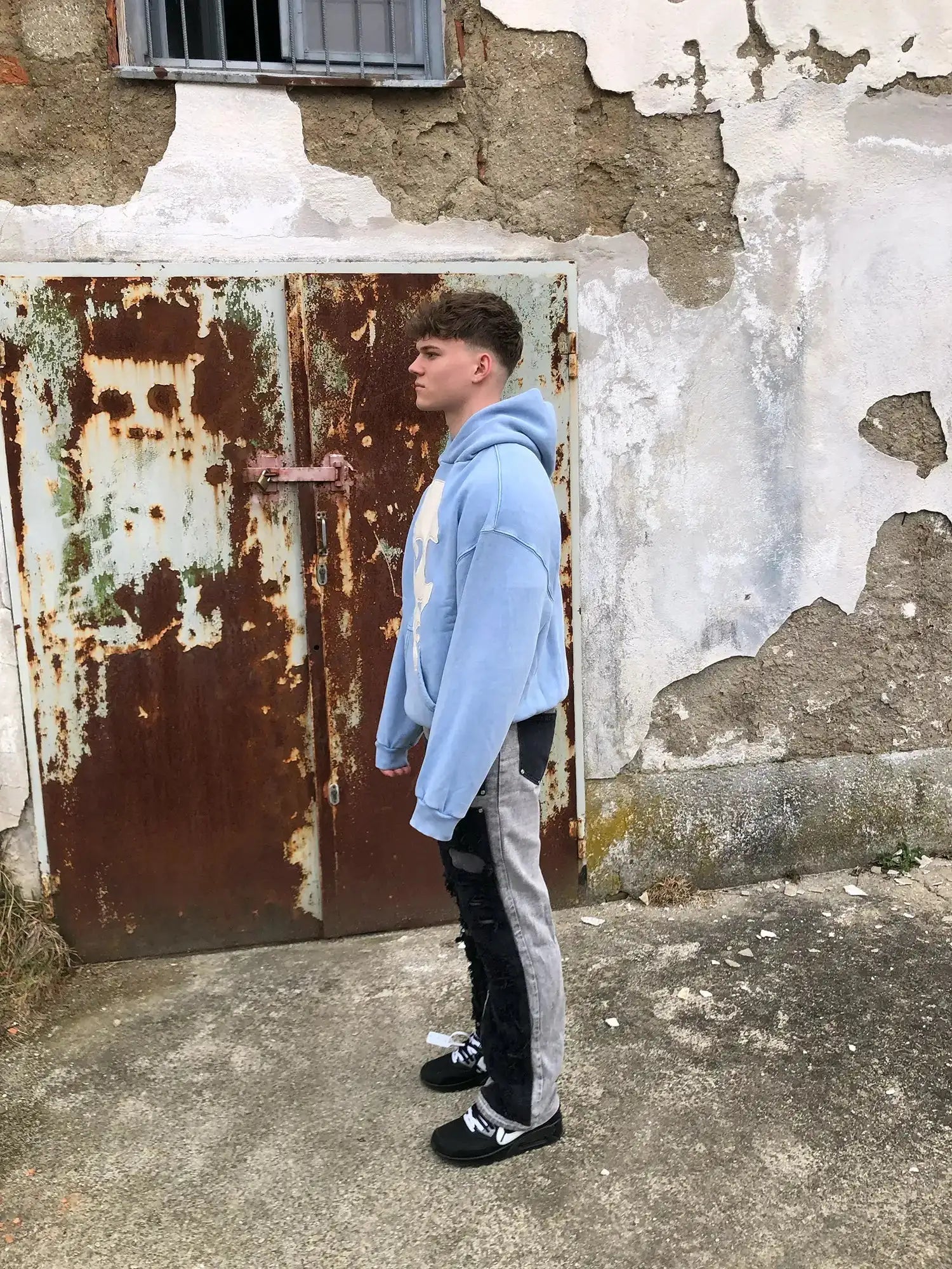 Side view of relaxed fit Faceless hoodie featuring off-white stitched face design