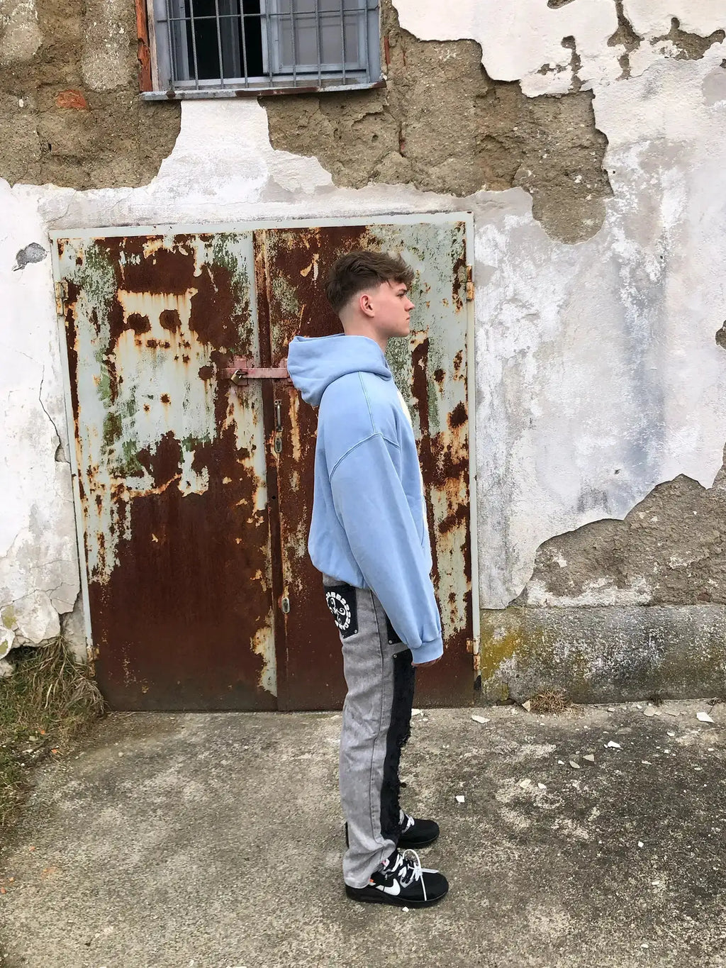 Model showcasing dropped shoulder silhouette of light blue Faceless organic cotton hoodie