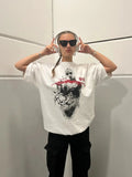 Model wearing loose fit white oversized t-shirt with black halftone portrait and red brushstroke design