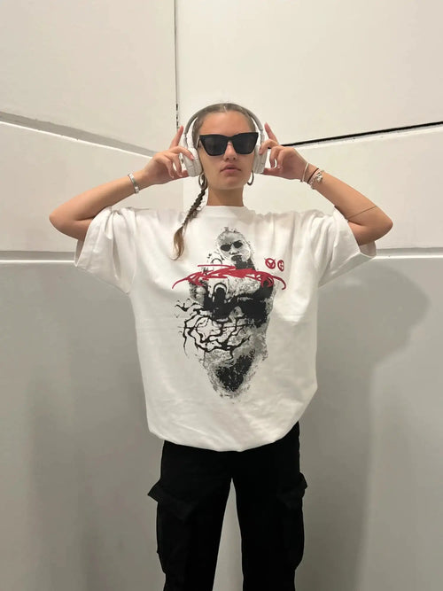 Model wearing loose fit white oversized t-shirt with black halftone portrait and red brushstroke design